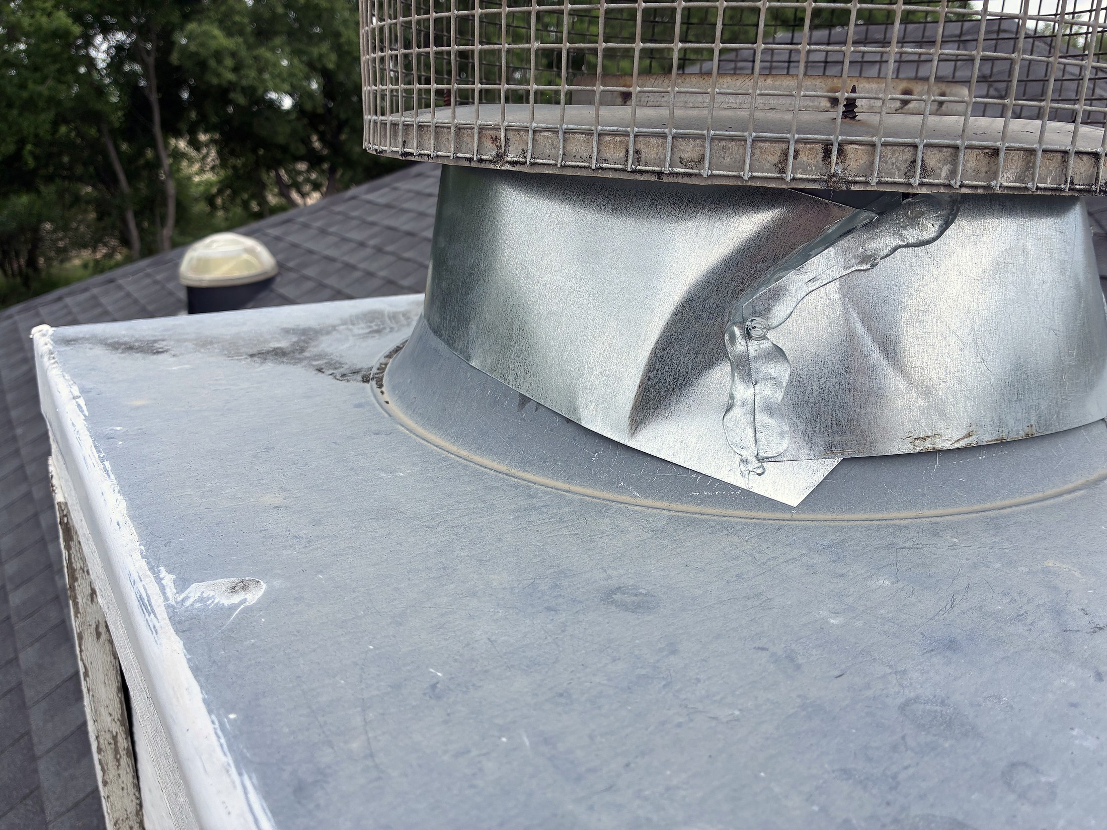 A turbine vent base flashed and sealed on a shingle roof